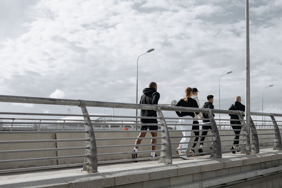 A group of adults jogging on a modern bridge, showcasing healthy lifestyle and exercise.