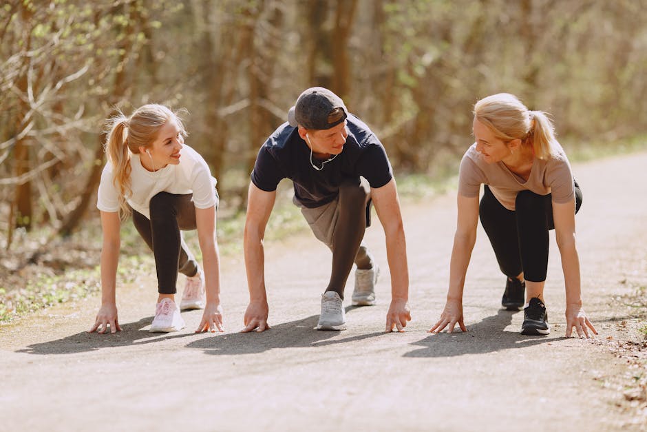 Group of cheerful athletes in sportswear in ready pose for sprinting together during fitness workout and running in spring park